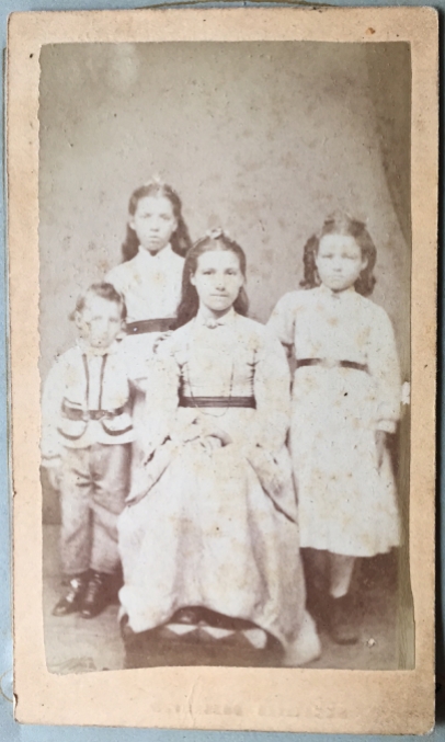 Photo 25: Three girls and one boy. Same imprint as John Elston's photo from the Wingham Fall Fair. Possibly four of his Elston children. Photographer W. Langdale, Wingham, Ontario. See 23b for reverse.